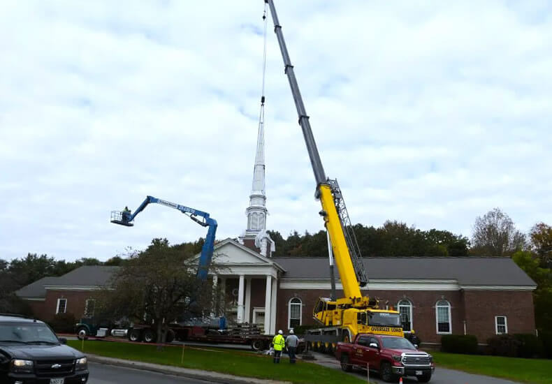 Sheridan Construction's crane in the process of removing the steeple from the Maine Children's Museum's new building.